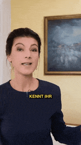 a woman stands in front of a painting with the word kennt ihr on her shirt