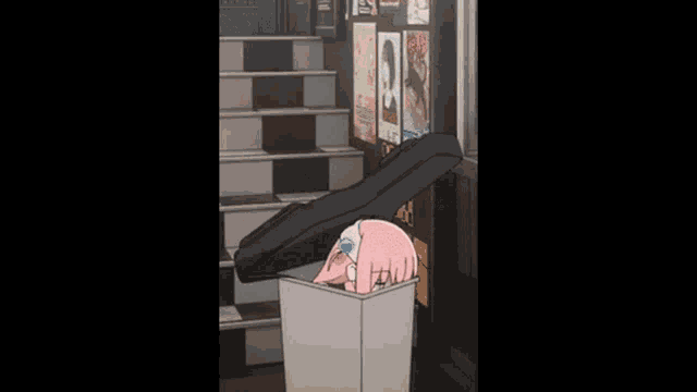 a girl in a pink jacket is kneeling down on a trash can .