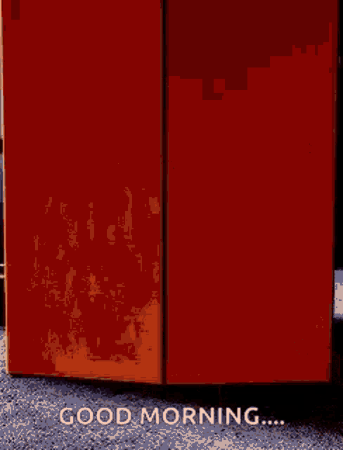 a person is standing in front of a red box that says `` good morning '' .