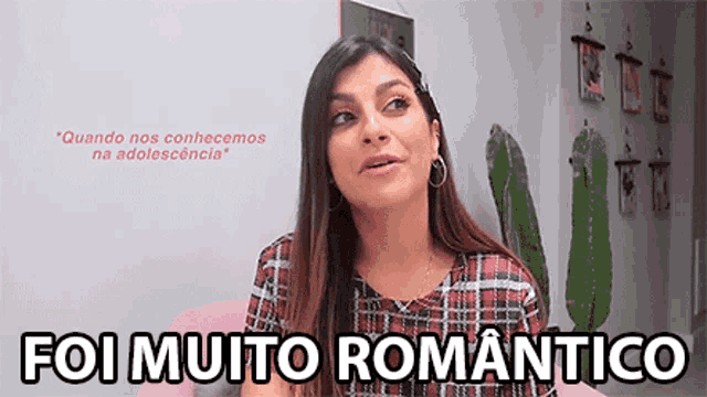 a woman in a plaid shirt is sitting on a pink couch and says " foi muito romantico " .