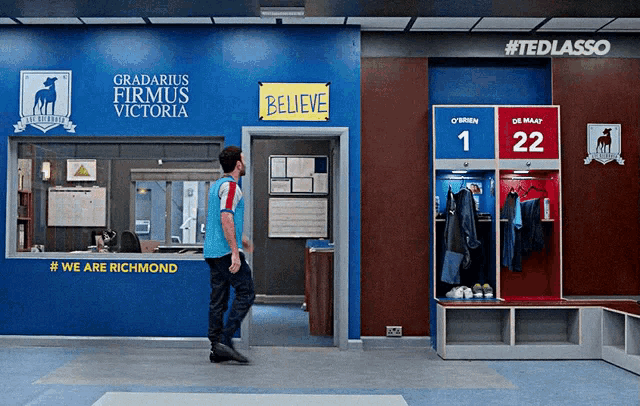 a man walks into a room with a sign that says believe on it