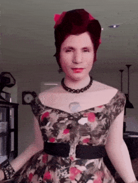 a woman is wearing a floral dress and a necklace .