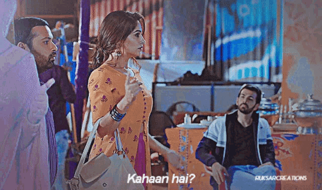 a woman standing next to a man with the words kahaan hai on the bottom right