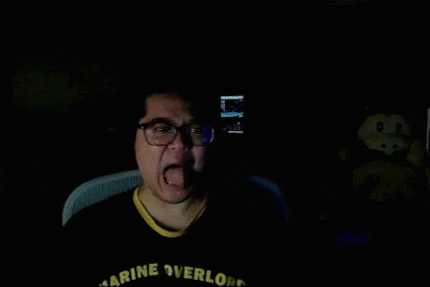 a man wearing glasses and a black shirt that says marine overlords sticking his tongue out