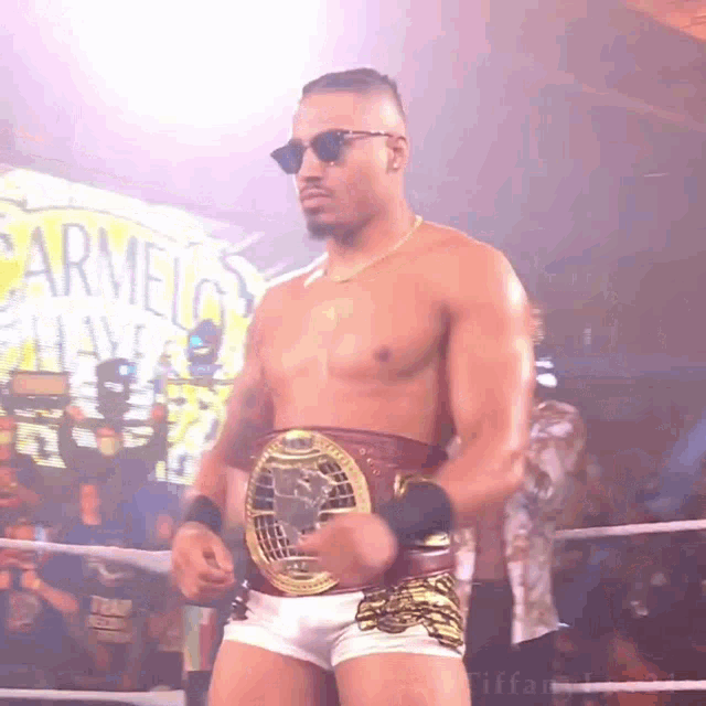 a shirtless wrestler wearing sunglasses and a belt with the word carmel on it