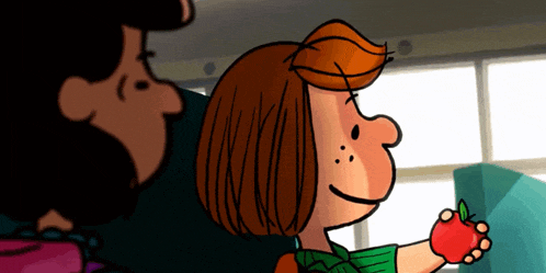 a girl in a green shirt is holding an apple