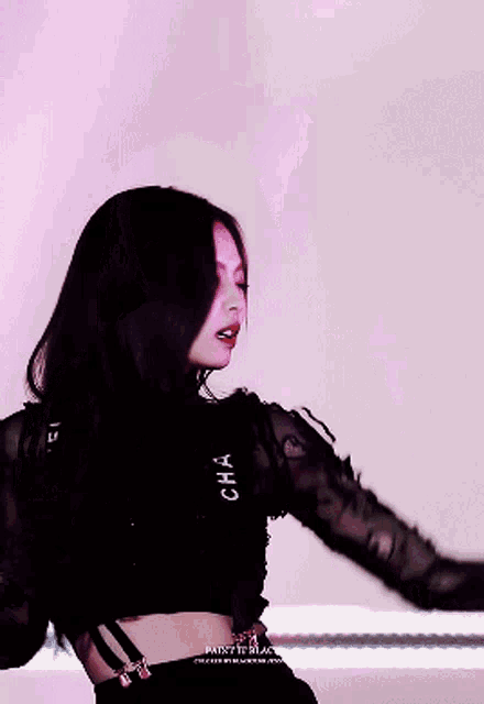 a woman wearing a black crop top with the word cha on the sleeve