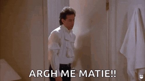 a man in a white shirt is standing in a bathroom and saying argh me matie !