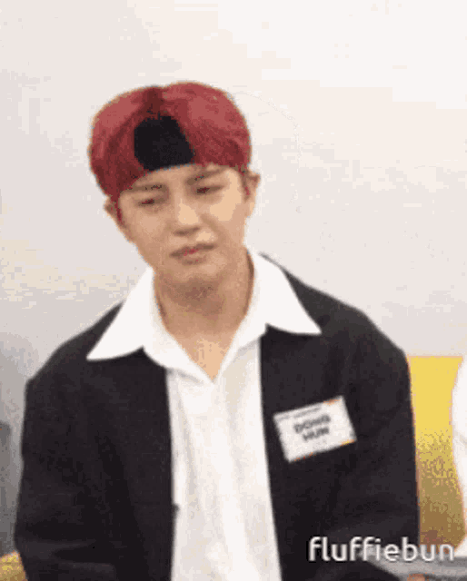 a man with red hair wearing a black jacket and white shirt