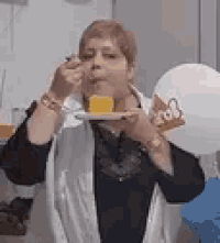an elderly woman is eating a piece of cake from a plate .