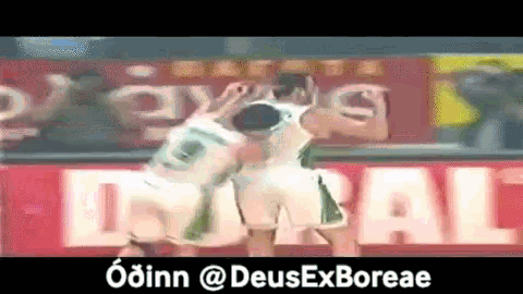 two soccer players celebrate a goal in front of a sign that says dubai