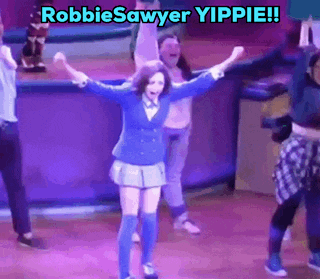 a group of people are dancing on a stage with the words robbie sawyer yippie written above them