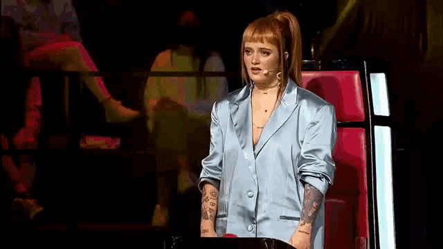 a woman is sitting in a chair with a microphone in her hand .