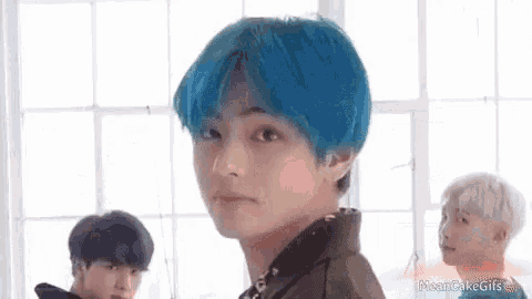 a boy with blue hair is standing in front of a window .
