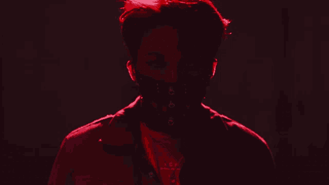 a man wearing a black mask and a red shirt that says acw on it