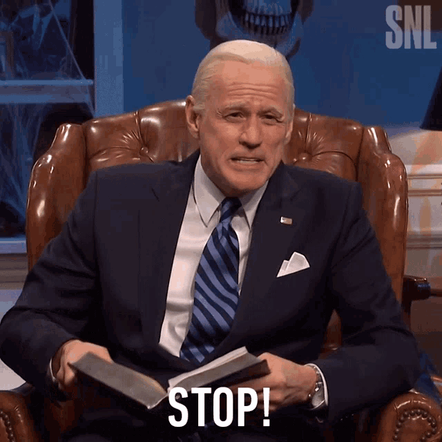a man in a suit and tie holds a bible and says " stop "
