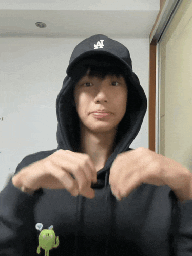a person wearing a la hat and a hoodie