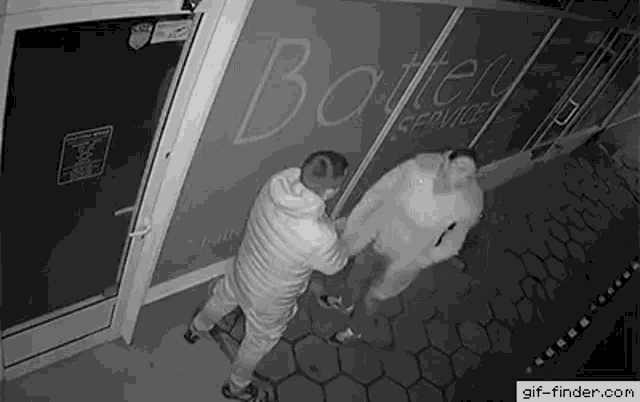 a couple of men are standing in front of a building .