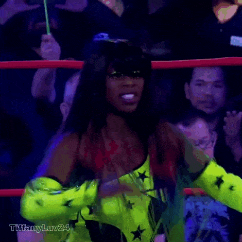 a woman in a neon green outfit is dancing in a ring with tiffanyluv24 written below her