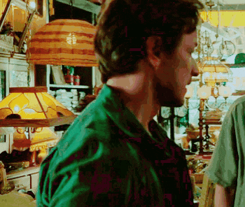 a man in a green shirt is standing in a store