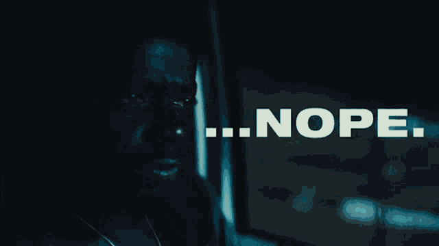 a man in a dark room with the word nope written above him