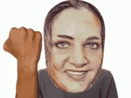 a woman is smiling and holding her fist in the air .