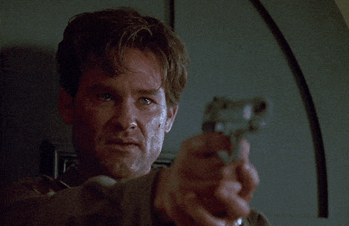 a man is pointing a gun at the camera in a movie