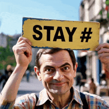 a man holding a sign that says stay #