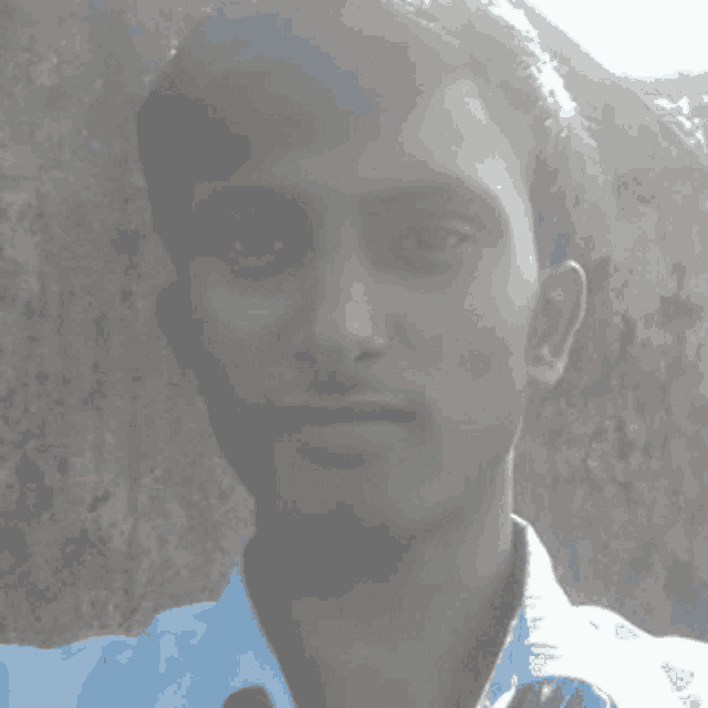 a man in a light blue shirt takes a selfie