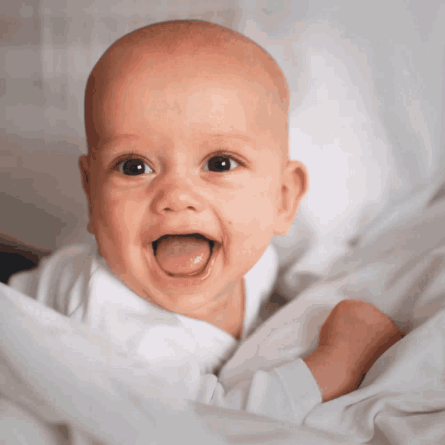 a baby with its tongue sticking out is smiling for the camera