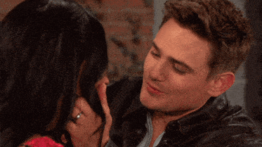 a man and woman are looking at each other and the woman is wearing a ring