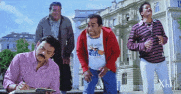 a group of men are standing in front of a building and one of them is wearing a shirt that says ' self style '