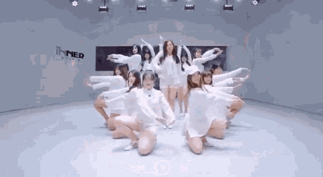 a group of women are dancing in a room with a sign that says inner studio .