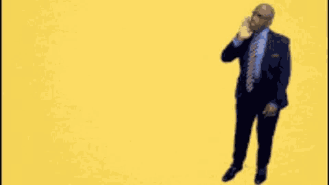 a man in a suit and tie stands in front of a yellow background that says sunday sunday sunday