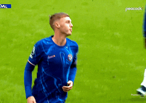 a soccer player in a blue shirt with peacock written on the bottom of his shorts