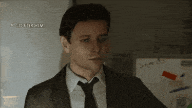 a man in a suit and tie is standing in front of a white board that says suggests