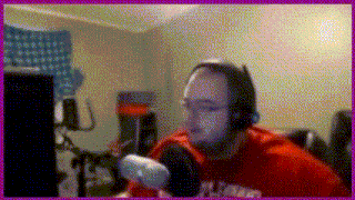 a man wearing headphones and a red shirt that says illinois is sitting in front of a microphone .