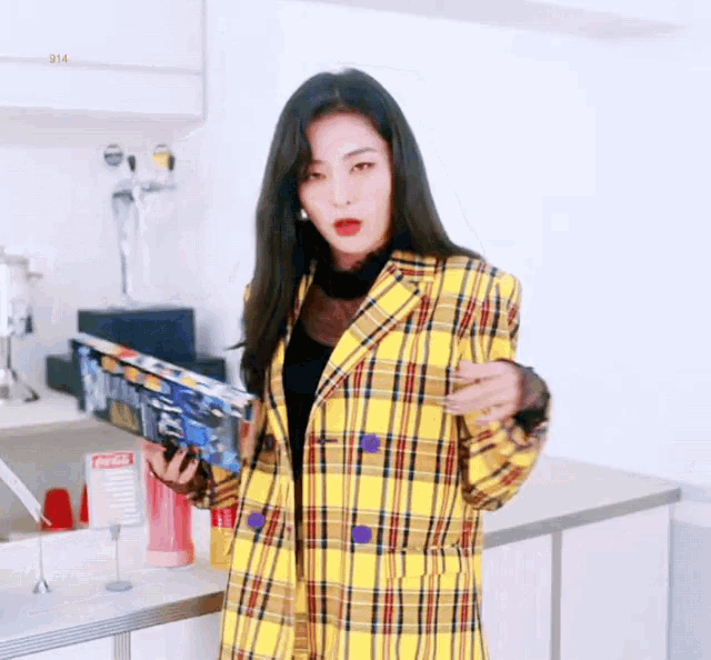 a woman in a yellow plaid jacket is holding a book