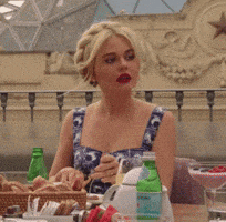 a woman is sitting at a table with a bottle of aquafina water