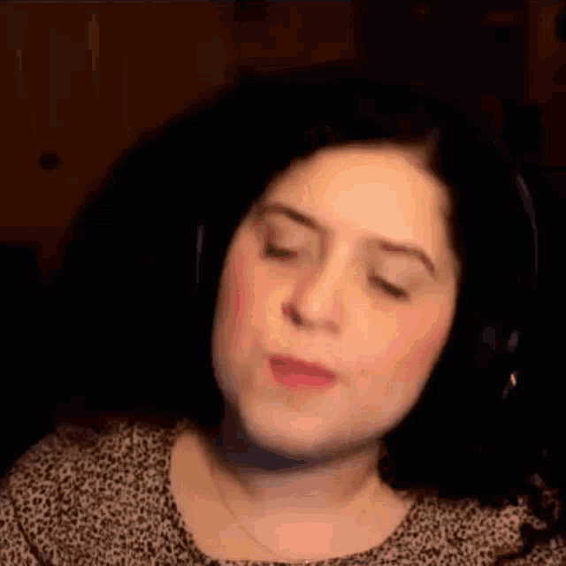a woman wearing headphones and a leopard print shirt is making a face