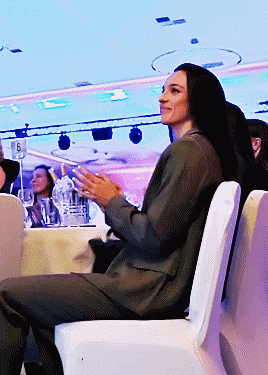 a woman sits in a chair with the number 6 on the table