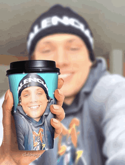 a person wearing a balenciaga hat is holding a cup