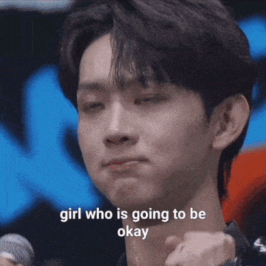 a close up of a man holding a microphone with the words girl who is going to be okay written on the bottom