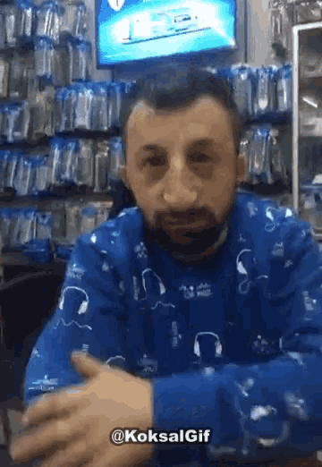 a man wearing a blue shirt with headphones on it is sitting at a table