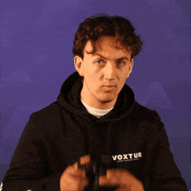 a man wearing a black hoodie with the word vo on it