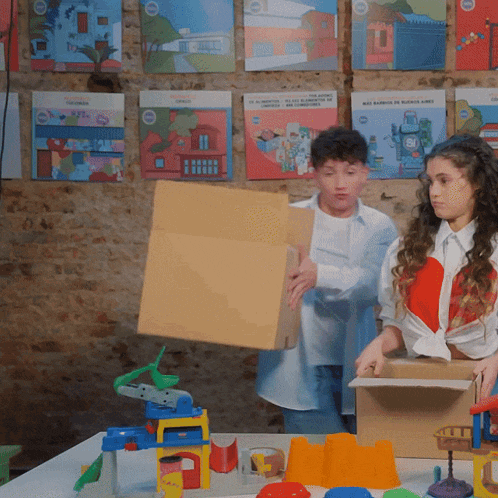 a boy and a girl are playing with toys in front of a wall with posters that say buenos aires on it