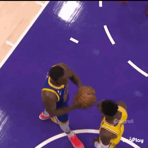 two basketball players are playing a game of basketball on a purple court