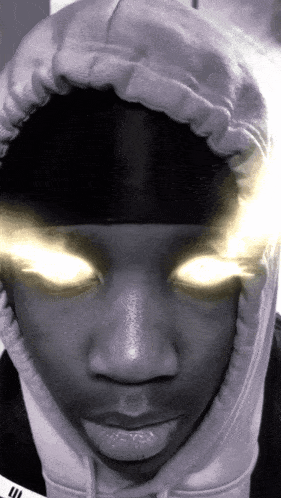 a close up of a person 's face with glowing eyes and a hoodie that says adidas on it