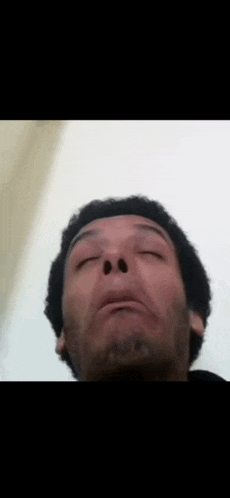 a close up of a man 's face with his eyes closed .