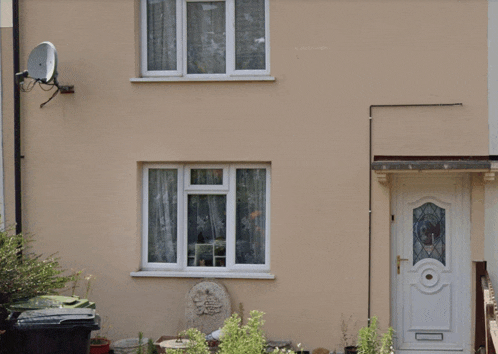 the front of a house with a white door and window